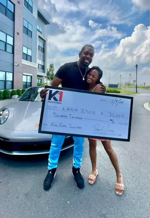 Lania Ison holding a $70,000 K1 Investors real estate investment check