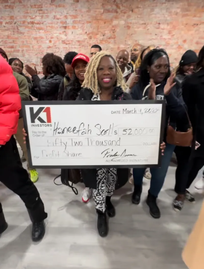 Haneefah Scott holding a $52,000 K1 Investors profit share check
